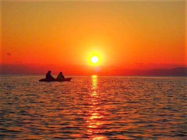 夕日が沈む様子を海の上で