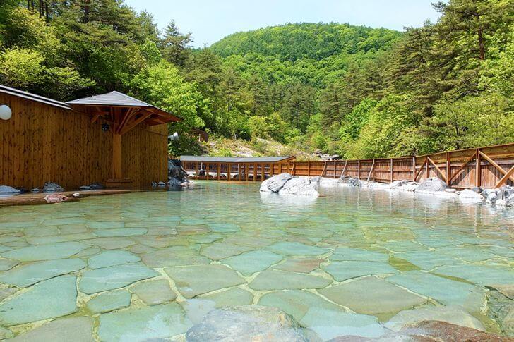 西の河原露天風呂(湯畑から徒歩15分)。男女合わせて500㎡という広さ!春は新緑が爽やかです。