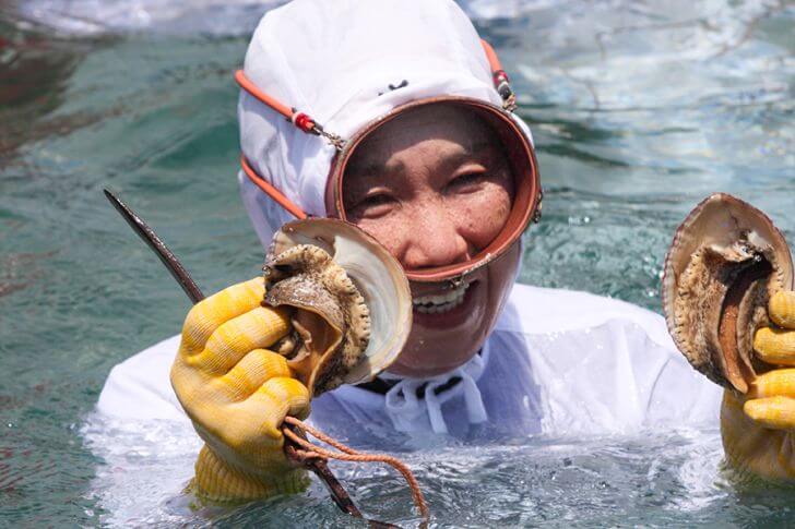 獲ってきたアワビを手にする海女さん。鳥羽の海を知り尽くしています。