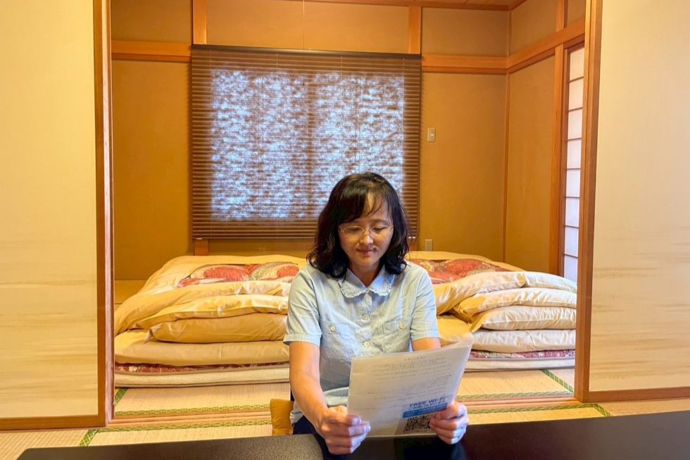 ふっくらとした布団を背に、案内を熟読するUさん