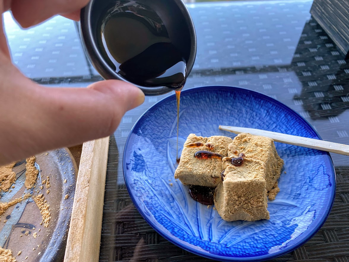わらび餅に黒蜜をかける様子