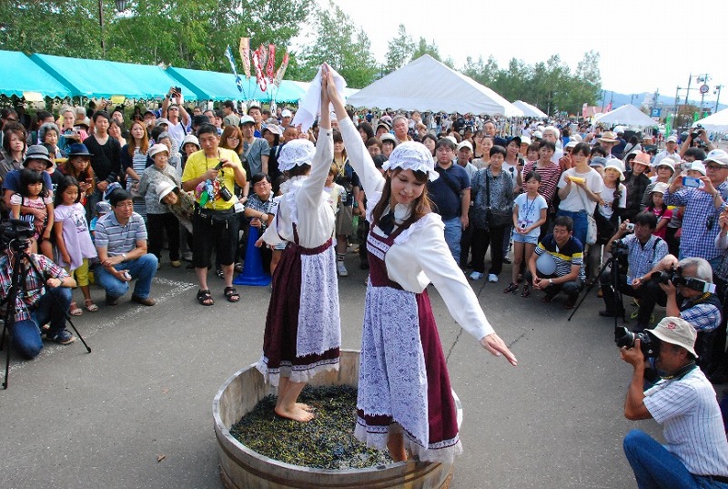 樽の中で音楽に合わせ足踏みしてワインを仕込む、昔ながらのぶどう踏み演舞 ふらのワインぶどう祭り