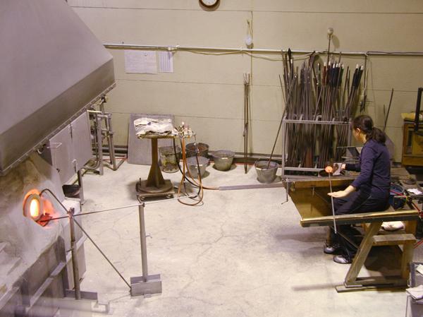 高温のガラスの素を、濡らした新聞紙を使って成形するホットワークの職人 ガラス製作過程を見学