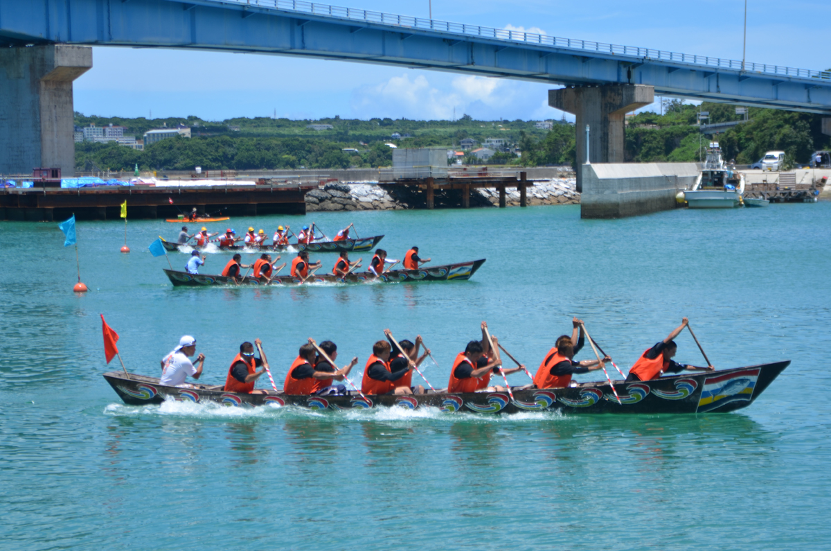 本部海洋まつりのメインプログラムともいえるハーリー大会。本部大橋をくぐってゴールを目指す 本部海洋まつりのメインプログラムともいえるハーリー大会