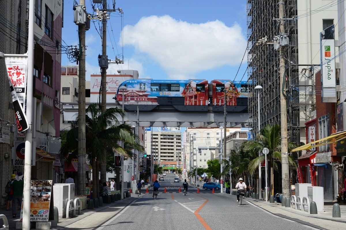 歩行者天国のすきまから顔をのぞかせるゆいレール。テーマパークのような景色だ 歩行者天国のすきまから顔をのぞかせるゆいレール。テーマパーク