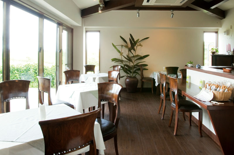 シックな店内の全面に広がる窓からは明るい光が差し込み、鮮やかな緑が見える。
建物内には貸しギャラリースペースもある 明るい光が差し込むシックな店内