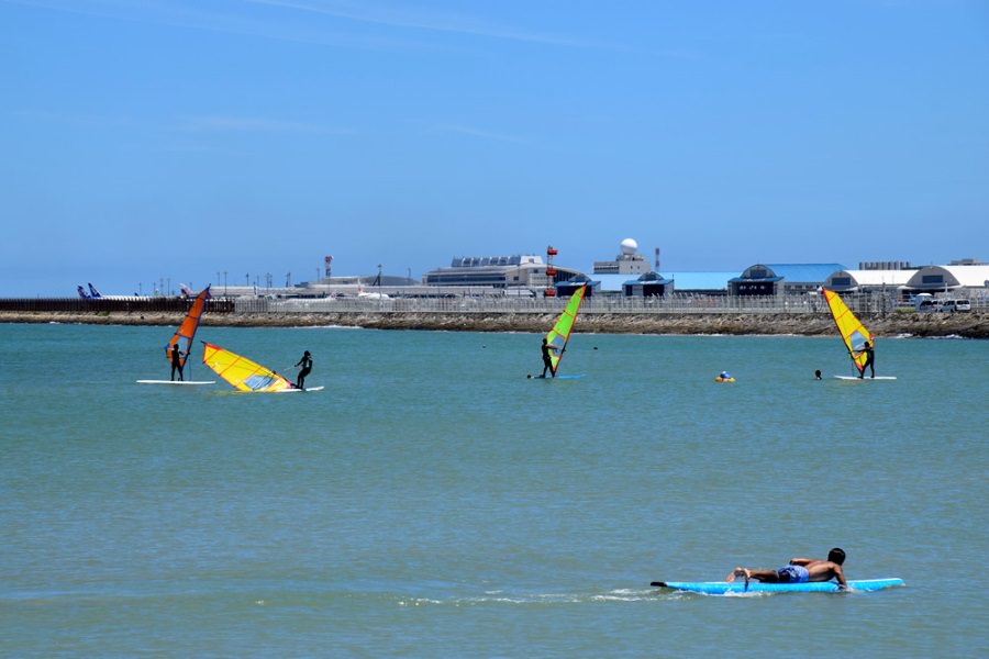 心地よい海風を受けてウィンドサーフィンを楽しむ人々