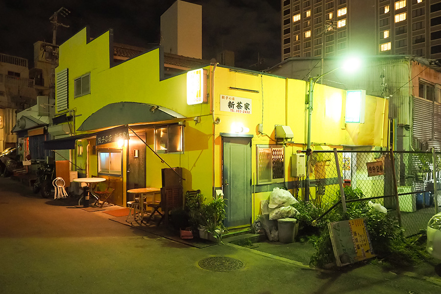黄色い外観が目を引く。店舗の前はコインパーキング