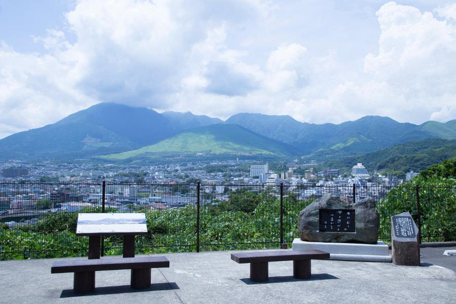 山の景色をわかりやすく紹介する案内板がベンチの前にあります