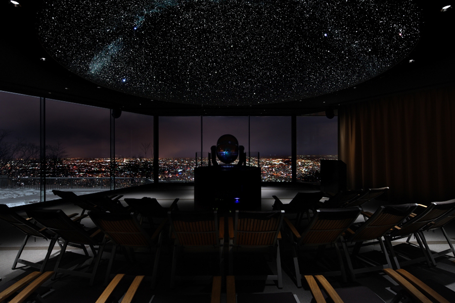 人工宇宙の向こうに札幌の夜景が見える。なんとも不思議で魅力的だ