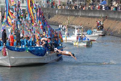 寒中の川に飛び込み、勇ましく泳ぐ若者
