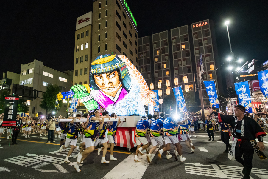 ライトアップされた山車が、中央通りを威勢よく練り歩く ライトアップされた山車が、中央通りを威勢よく練り歩く