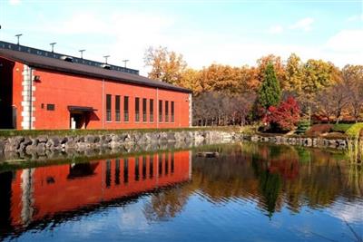 赤いレンガ造りの貯蔵庫と紅葉が水面に写るこの時期ならではの風