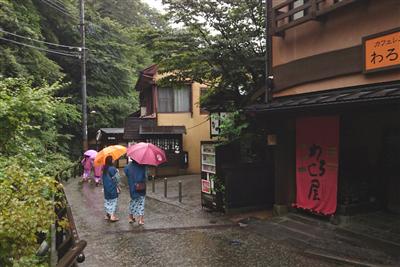雨の中の散策を楽しむ黒川温泉の宿泊客たち