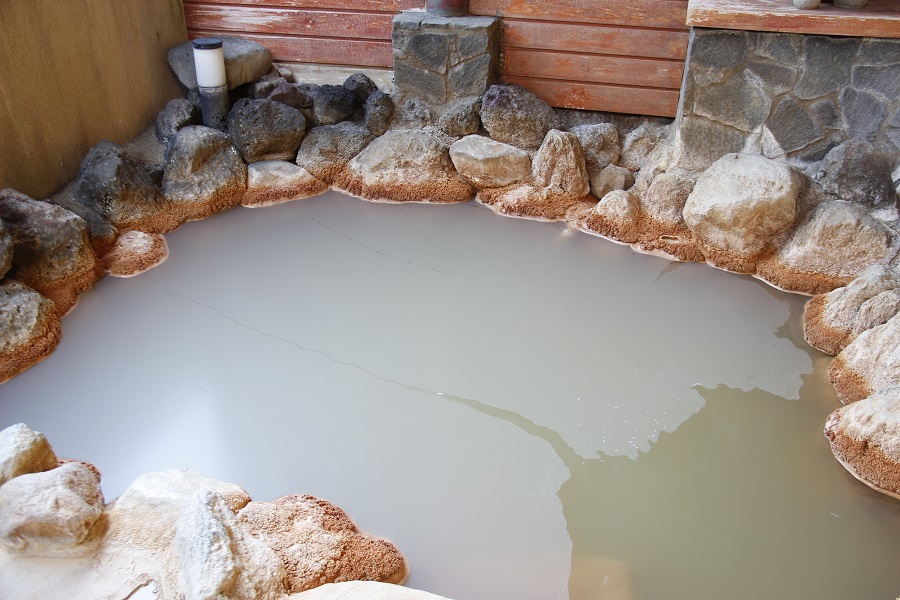 露天風呂に浮かぶ白い膜が赤城温泉の特徴である石灰花