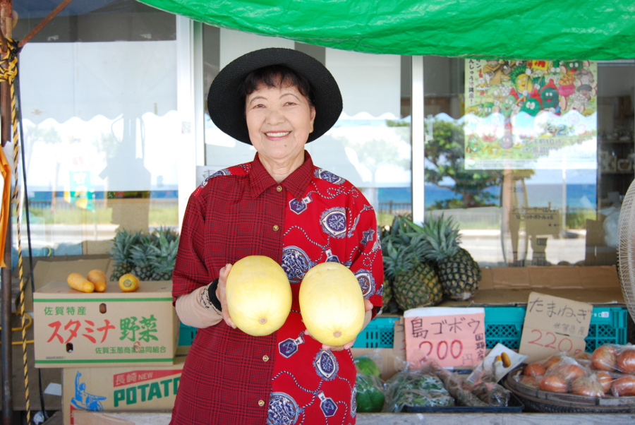 「おいしいわよ〜めしあがれ！」と笑顔で話す平良さん