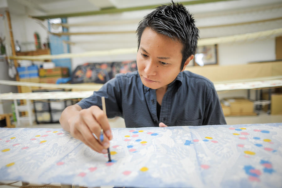 2本の筆を巧みに使い、布を染め上げていく宮城さん