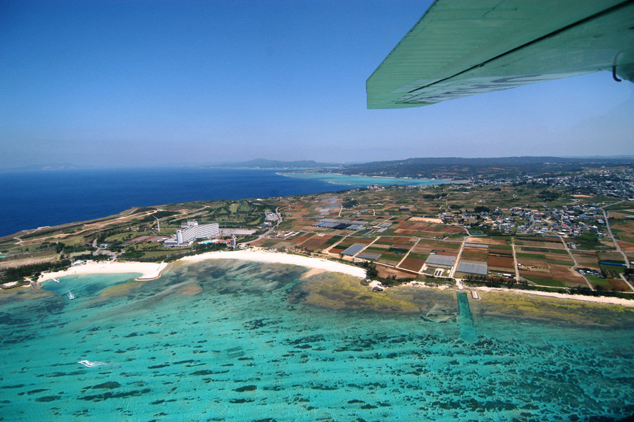 海と畑、のどかな風景が広がる空から見た読谷 