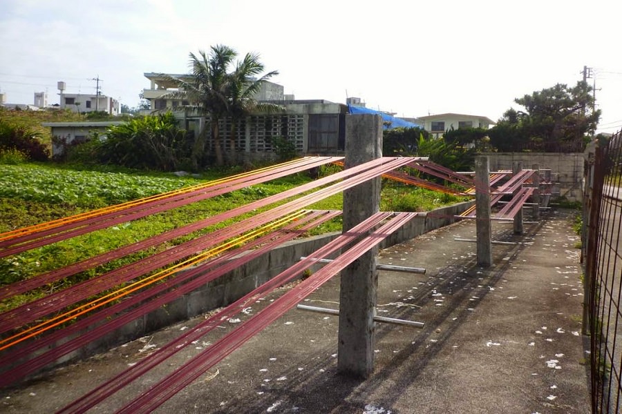 模様のズレを防ぐため、糸はのりづけし、伸ばして干す