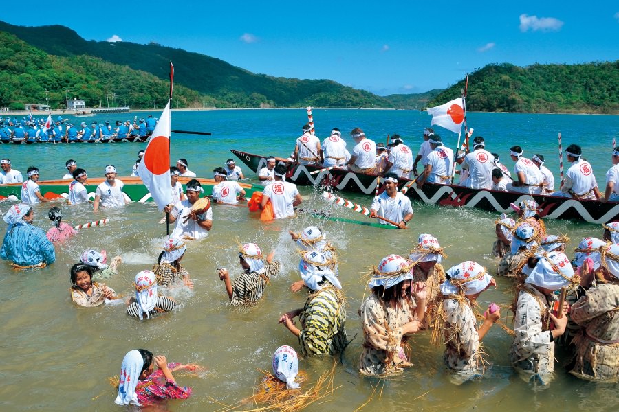 村の女性が腰まで海水に浸かり、漕ぎ手を応援する姿は圧巻！