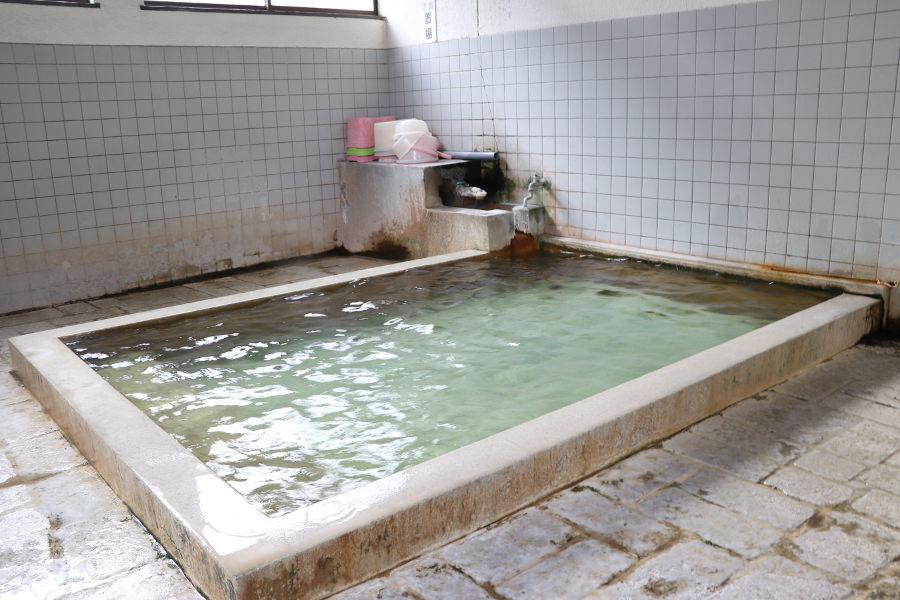 共同浴場「地獄原温泉」は、賽銭箱に100円を入れて利用する