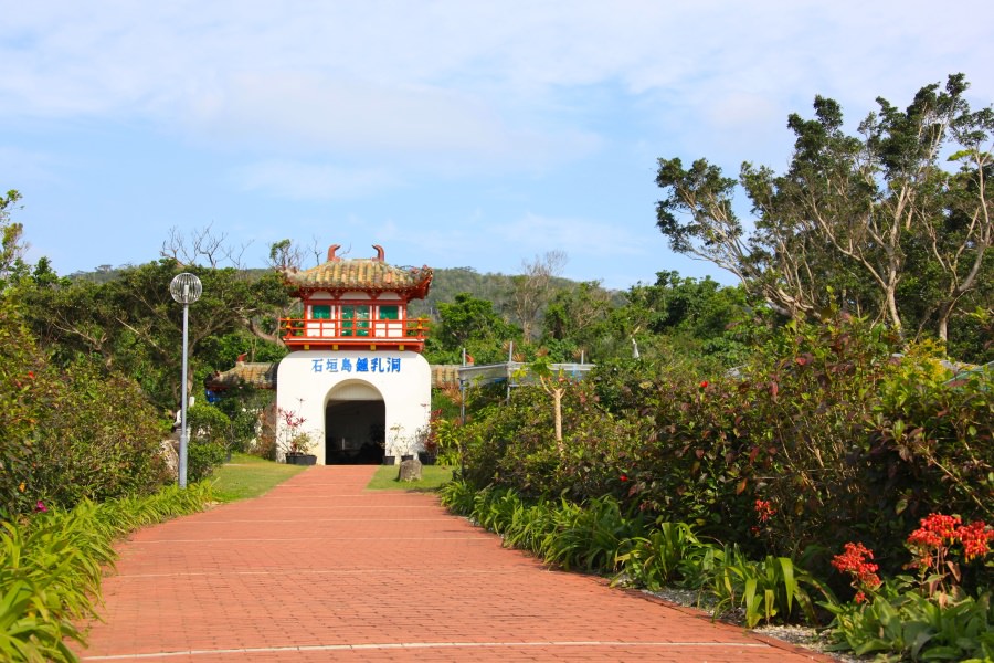 亜熱帯植物に囲まれた首里城風の建物が鍾乳洞への入り口
