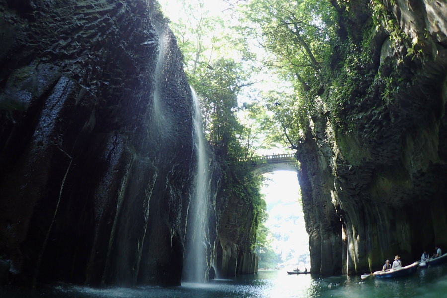 高千穂峡をボート上から見ると、降り注ぐ滝の水しぶきが輝く