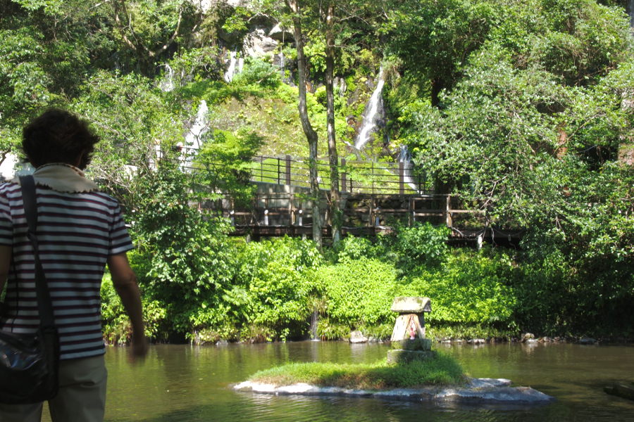 おのころ池に浮かぶおのころ島と、奥の岩壁の玉垂の滝