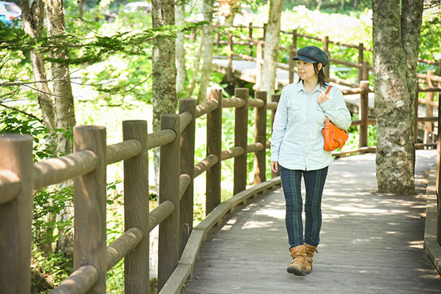 神の子池の木道と女性