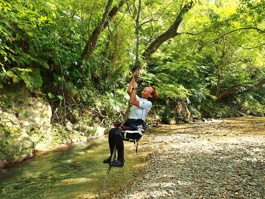 川でターザンごっこをして遊ぶ