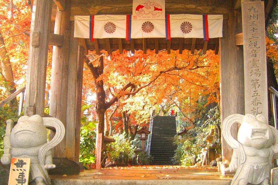 「無事にカエル」の文字と一緒に並ぶ阿吽像のようなカエルの石像