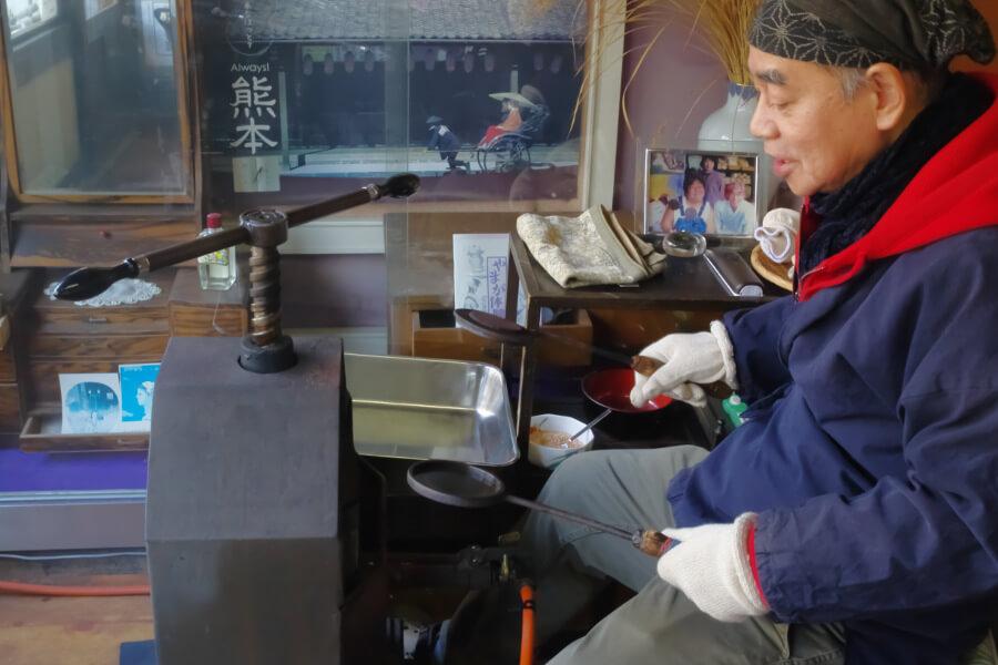 厳選された熊本県産米を入れた煎餅型をとろ火にかけて、キュッとプレス