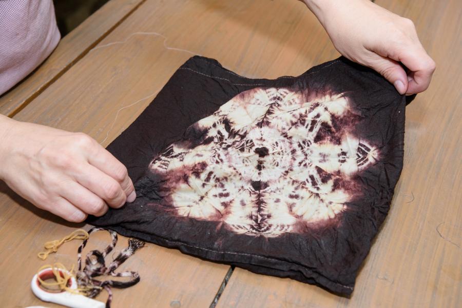 泥染めの後は水洗いし生地を煮込みます。事前に仕掛けていた部分をほどくと、泥染めの柄がくっきりと仕上がりました