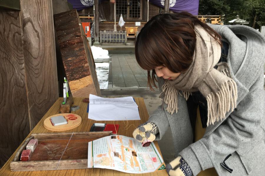 神門下で三社めぐりのパンフレット（スタンプ台紙）を入手してひとつ目のスタンプを。3つすべて回ると商店街の交換店で「福銭」と交換してもらえます