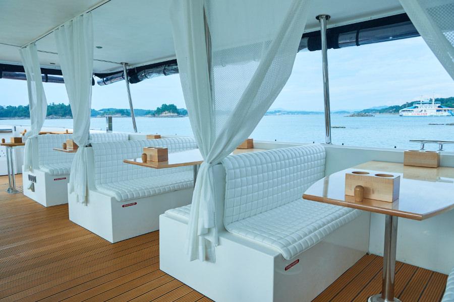 温かみのある木製のデッキやテーブル。デザインは、クルーズトレイン「ななつ星in九州」を手掛けた「水戸岡鋭治＋ドーンデザイン研究所」です