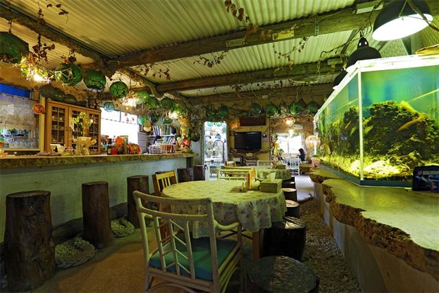 店内には各種オブジェや亜熱帯植物、巨大な水槽にピアノと賑やか
