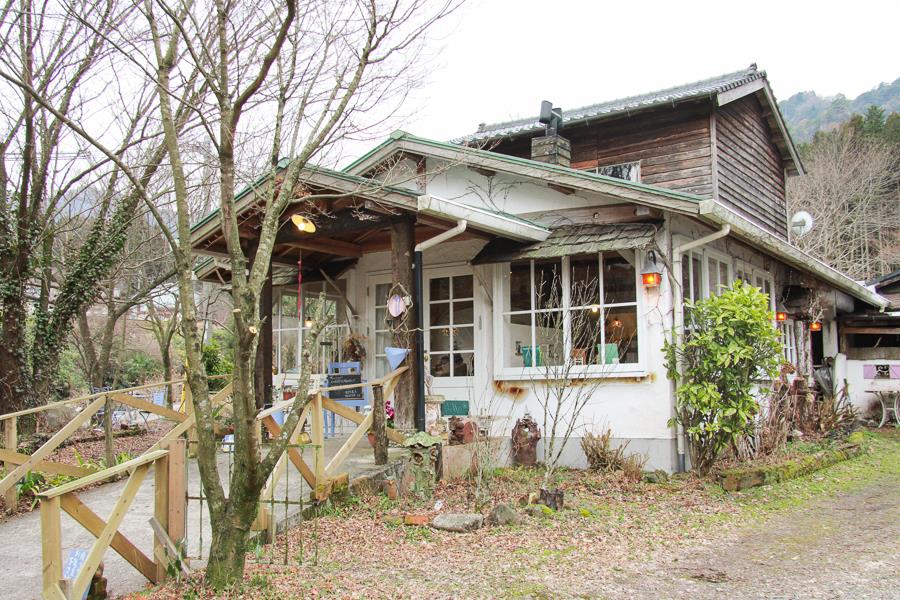 白川水源から車で約10分。「のほほんcafe ボワ・ジョリ」は、白を基調としたおしゃれな佇まい。玄関に飾られているおしゃれな小物や、看板に期待感も膨らみます