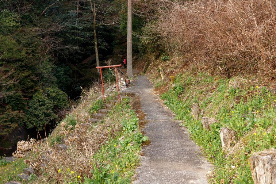 道は渓谷沿いに進む。大きな岩壁や生い茂る緑が迫ります