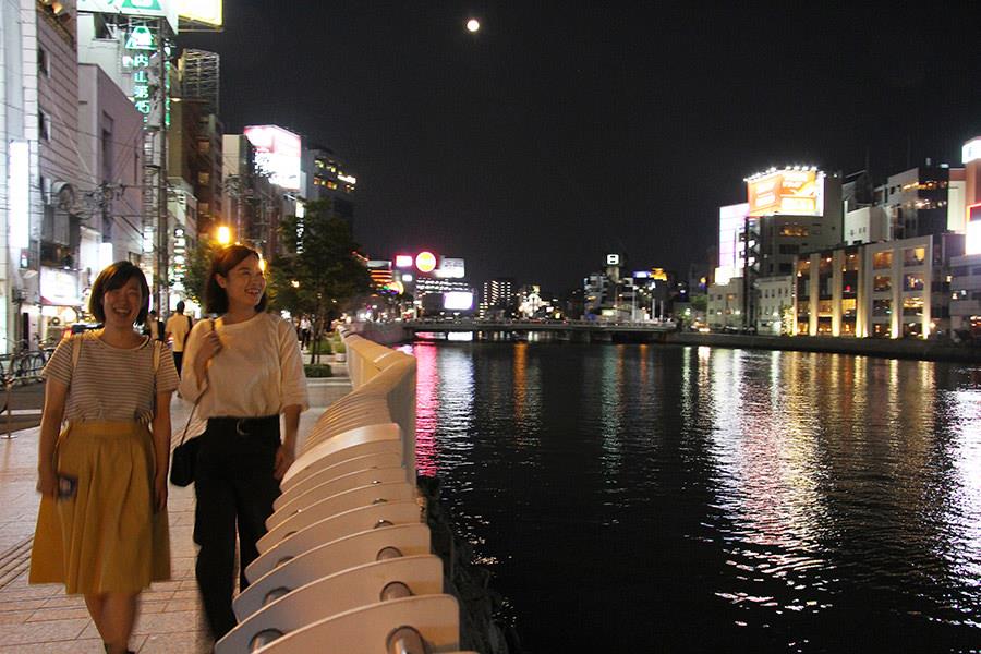 屋台を楽しんだ後は、赤くなった頬を冷ましに川沿いをお散歩。川に映る色とりどりのネオンが美しく、思わず見惚れてしまいます