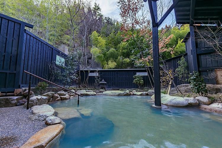 目の前にびょうぶ岩が迫る露天風呂。気候や時間帯によって、湯の色がエメラルドグリーンに変化します。夜になるとライトアップされ、幻想的な雰囲気に